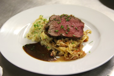 Rosa gebratener Hirschrücken mit Nusskruste an Portweinjus, karamellisiertem Spitzkohl und Thymian-Kartoffel-Stampf